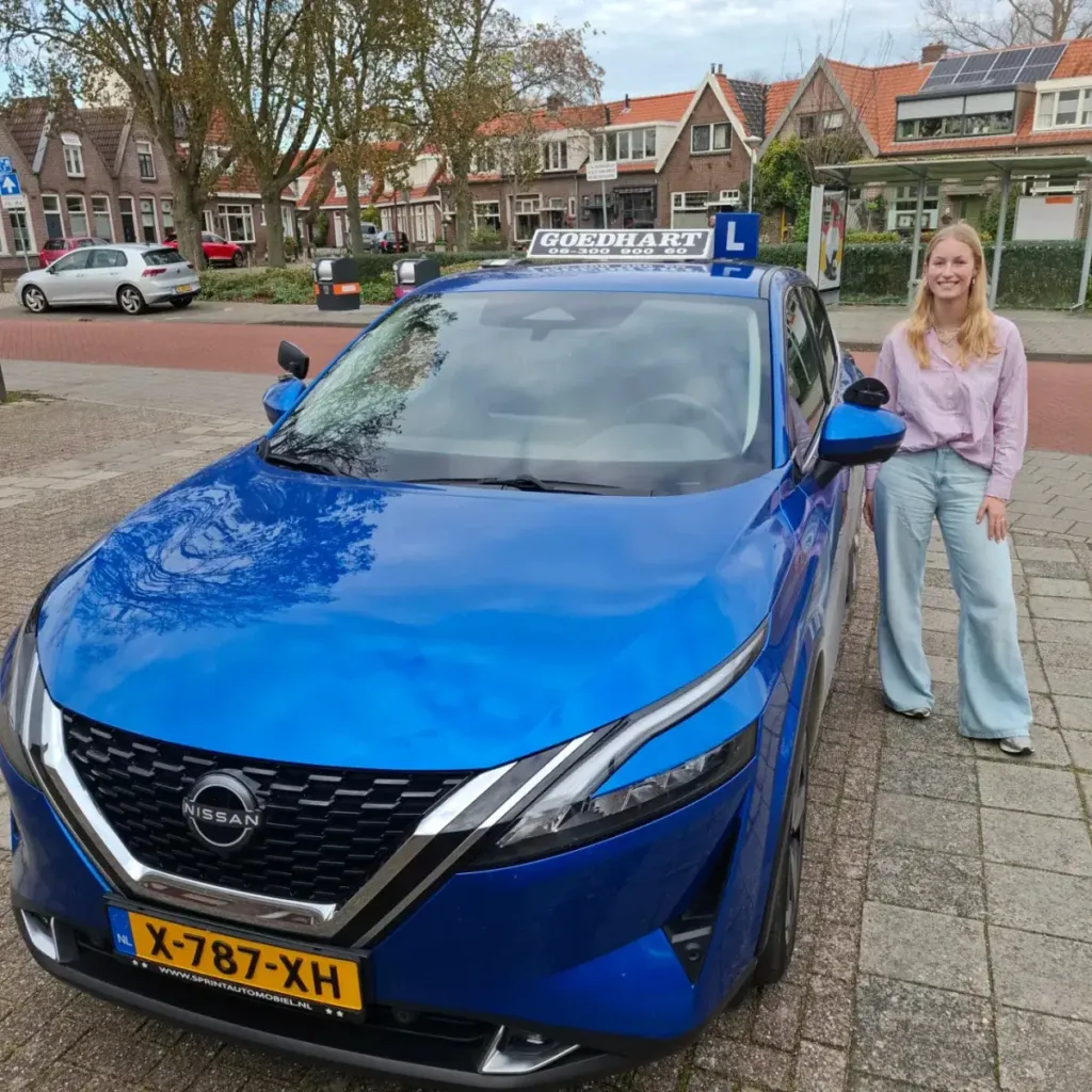 Geslaagde leerling Floortje bij de blauwe lesauto van Autorijschool Goedhart