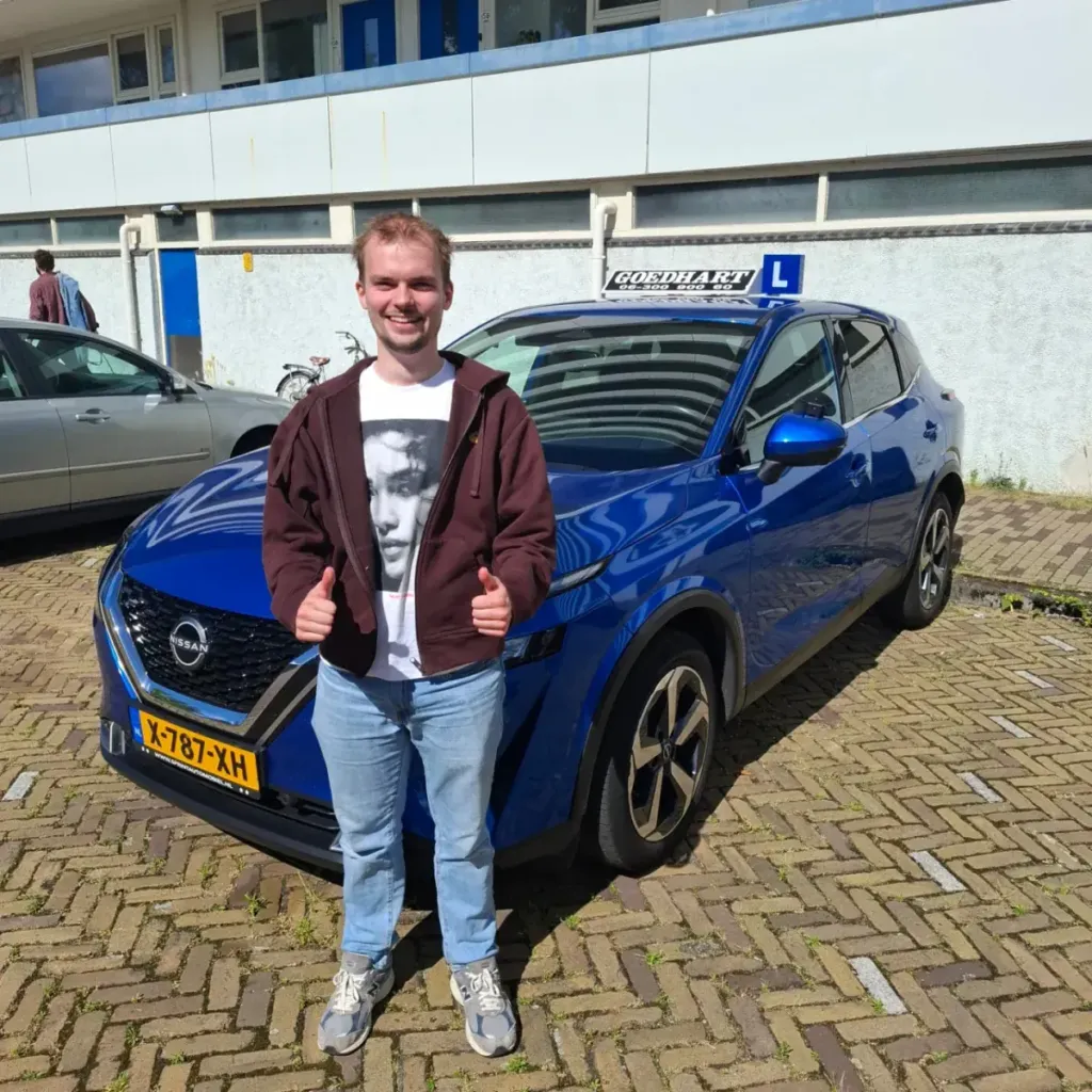 Geslaagde leerling Lars bij de blauwe lesauto van Autorijschool Goedhart