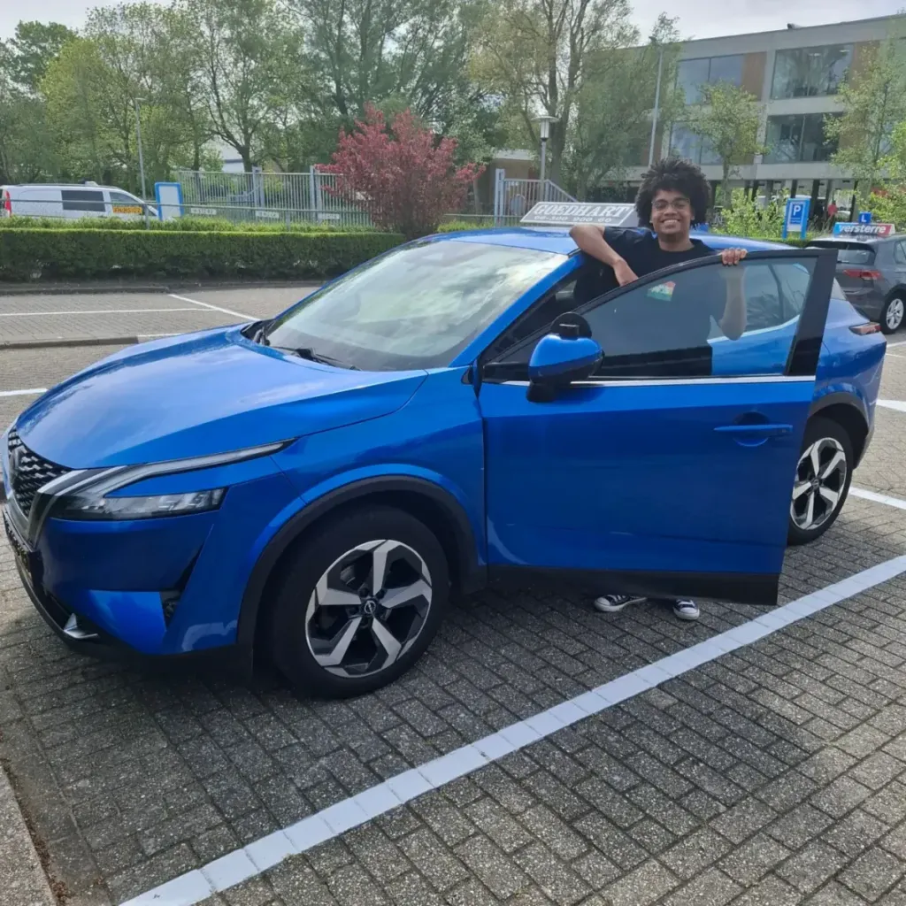 Geslaagde leerling Stefan bij de blauwe lesauto van Autorijschool Goedhart