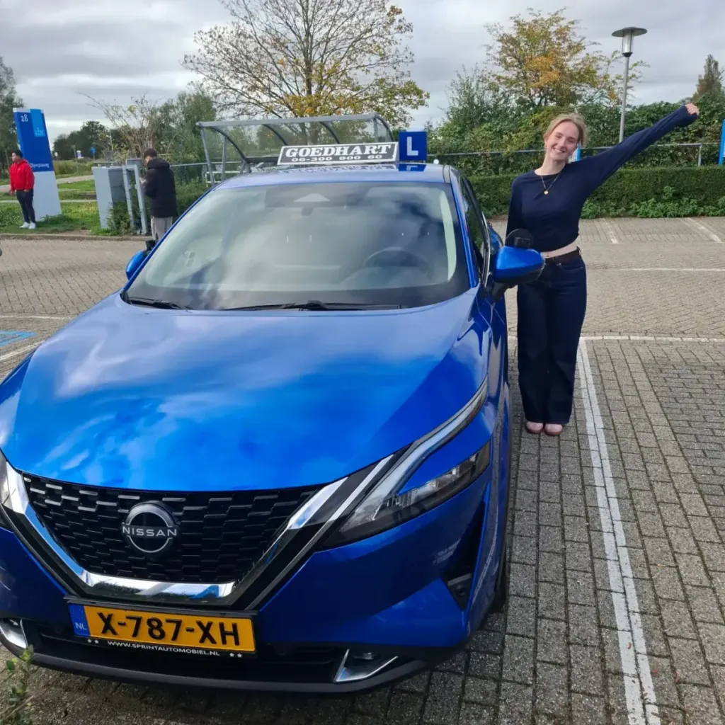 Geslaagde leerling Zoey bij de blauwe lesauto van Autorijschool Goedhart